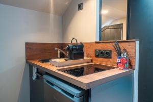 a kitchen counter with a sink and a mirror at Résidence Saint-Louis - Appart'Hôtel tout-équipé in Cholet +24 photos