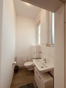 een witte badkamer met een toilet en een wastafel bij Zur schönen Aussicht I 35 I Charmant I Am Feld in Dortmund