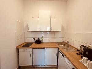 een keuken met witte kasten en een spoelbak bij Zur schönen Aussicht I 35 I Charmant I Am Feld in Dortmund +11 foto's