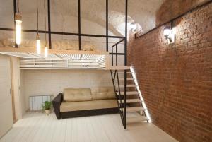 a loft bed in a room with a brick wall at Kolman Apart in Saint Petersburg