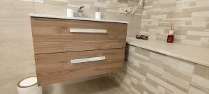 a bathroom with a sink and a wooden cabinet at A casa di Gino in Molfetta
