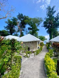 a walkway through a garden with buildings and trees at Coco Beach Resort in Port Vila