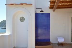 a bathroom with a shower with blue tile at Terrazza Aragonese in Ischia Town