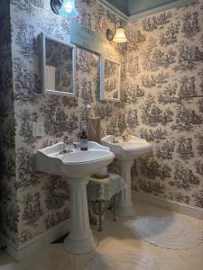 baño con 2 lavabos y papel pintado con motivos florales en Historical downtown Lind House Studio, en Pensacola