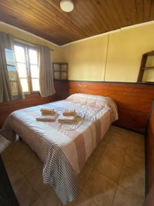 a bedroom with a bed with two towels on it at Cabaña Los Huemules in El Chalten +7 photos