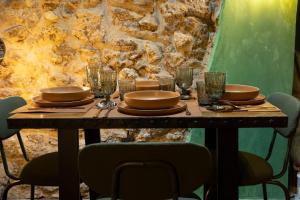 una mesa de madera con platos y vasos. en Rustico di charme, en Fiano Romano