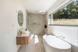a bathroom with a tub and a sink and a mirror at Farm Retreat with Ocean Views, Fireplace & Bath in Rose Valley +42 photos