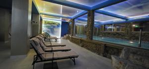 a pool with a row of chairs and a swimming pool at Bali Colosseum Hotel in Belgrade