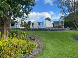 two domes on top of a house with a yard at Rainbow Rose in Orere Point