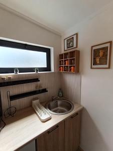 een badkamer met een wastafel en een raam bij Vikendica Blagojević Čačak in Čačak