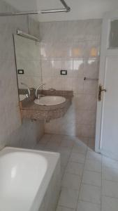 a bathroom with a sink and a tub and a mirror at Oscar Hotel Aswan 中國人之家 in Aswan +43 photos
