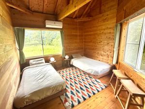 a room with two beds in a log cabin at Koguchi Village by WhyKumano in Shingū