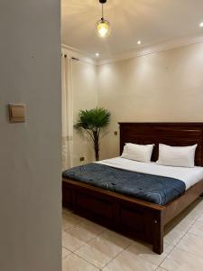 Un dormitorio con una gran cama de madera en una habitación. en The creative space, en Kampala