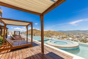 a house with a deck with a swimming pool at Luxury Pedregal Condo - Views, Pool & Concierge in Cabo San Lucas