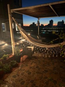 a hammock on the roof of a building at night at Charming flat with big private Terrace in Montevideo +22 photos