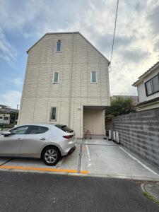 ein Auto, das auf einem Parkplatz vor einem Gebäude geparkt ist in der Unterkunft Private stay, fully equipped 45 square meter, Easy access to Disneyland & Airports in Tokio