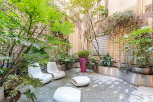 a garden with white chairs and plants on a sidewalk at BreraPrivata - appartamento con giardino e spa ad uso esclusivo - Milano in Milan