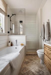 a white bathroom with a tub and a toilet at Breckenridge Alpine Residence in Breckenridge