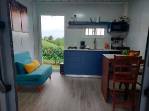 a kitchen with blue cabinets and a blue chair and a table at Cabaña Tesoro Escondido in Guápiles