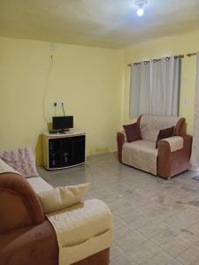 un soggiorno con due divani e una TV di Casa de Temporada em Monte G & Guarajuba a Monte Gordo Altre 13 foto