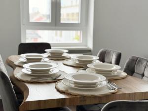 a wooden table with white plates and dishes on it at Offenbach 200 m2 9 Betten O2 EG in Offenbach