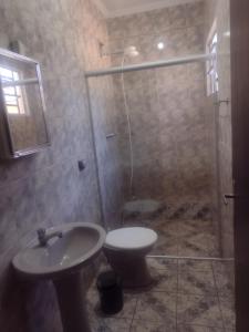a bathroom with a shower and a toilet and a sink at Casa na área central com 3 quartos in São Pedro +12 photos