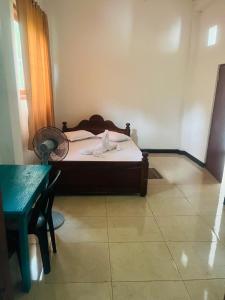 a small bedroom with a bed and a table at Winland Coffee & Stay in Kitulgala