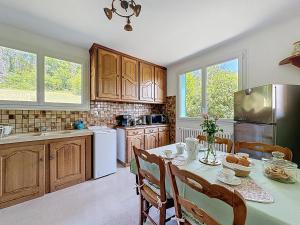 a kitchen with a table and chairs and a refrigerator at chez Anne in Tanlay