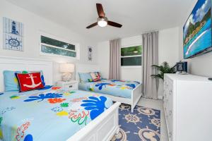 a bedroom with two beds and a ceiling fan at Lexy Beach House in Cape Canaveral
