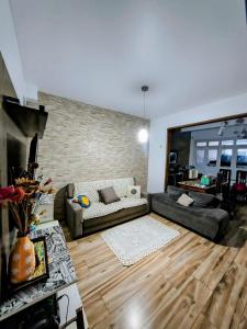 a living room with a couch and a brick wall at Casa do Marco&Leoni in Belém