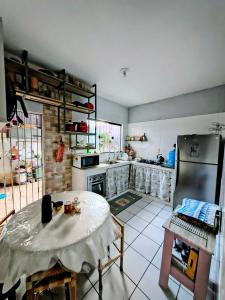 a kitchen with a table and a refrigerator at Casa do Marco&Leoni in Belém