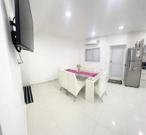 una cucina bianca con tavolo e frigorifero di CASA MODERNA en Barrio a Villa Ángela Altre 12 foto