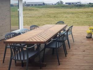 Torstedにある6 person holiday home in Thistedのデッキの上の木製のテーブルと椅子