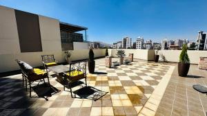 a patio with chairs and tables on top of a building at Valley Wasi Hostel in Cochabamba
