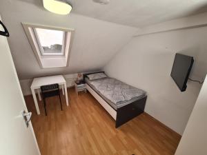 a small room with a bed and a table and a window at Boardinghouse Haigerloch - Monteur & Business Apartments powerd by Rent House GmbH in Haigerloch