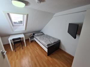 a small room with a bed and a desk and a window at Boardinghouse Haigerloch - Monteur & Business Apartments powerd by Rent House GmbH in Haigerloch