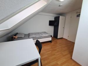 a room with a bed and a table in a attic at Boardinghouse Haigerloch - Monteur & Business Apartments powerd by Rent House GmbH in Haigerloch