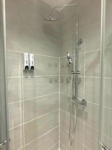 a shower with a glass door in a bathroom at Cambridge House in Manchester