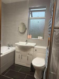 a bathroom with a sink and a toilet and a mirror at Cambridge House in Manchester