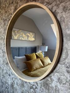 een slaapkamer met een ronde spiegel boven een bed bij Blackburn Heights Sleeps 4 Family Apartment in Bridlington