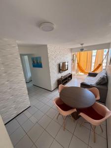 a living room with a table and chairs and a couch at Appartement mon amour à 200m de la plage in Cumbuco +5 photos
