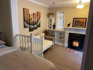 Un dormitorio con cuna y chimenea en una habitación. en Suit near Grousmountain, en North Vancouver