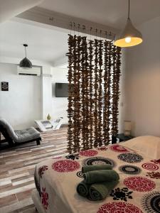 a bedroom with a bed with a wall of beads at EDEN-RÉSIDENCE Le TOBAGO Vue Mer et Piscine in Sainte-Luce