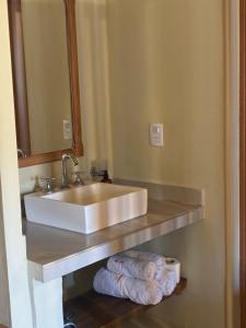 a bathroom with a sink and towels on a shelf at Balconcito de Colores in Maimará +25 photos