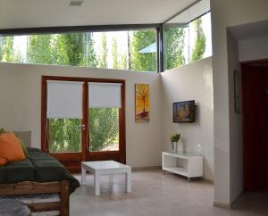 a living room with a couch and some windows at Casa Puentes Amarillos in Malargüe