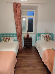 two beds in a room with a window at Casa da Nogueira in Alvorninha