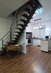 a living room with a staircase and a kitchen at Casa da Nogueira in Alvorninha