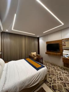 a hotel room with a bed and a television at روح المدينة السكنية in Al Madinah