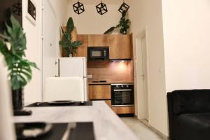 a small kitchen with a refrigerator and a couch at Luxe Living Studio in Tirana
