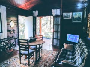 a living room with a table and a couch at Casa campos recanto in Campos do Jordão